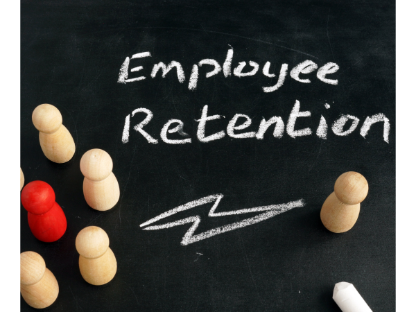 Wooden figures on a chalk board with the words "Employee Retention" written in chalk.