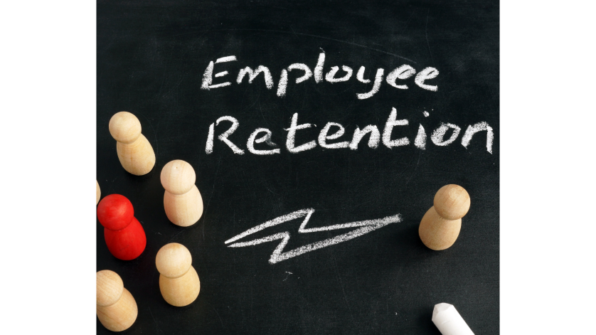 Wooden figures on a chalk board with the words "Employee Retention" written in chalk.